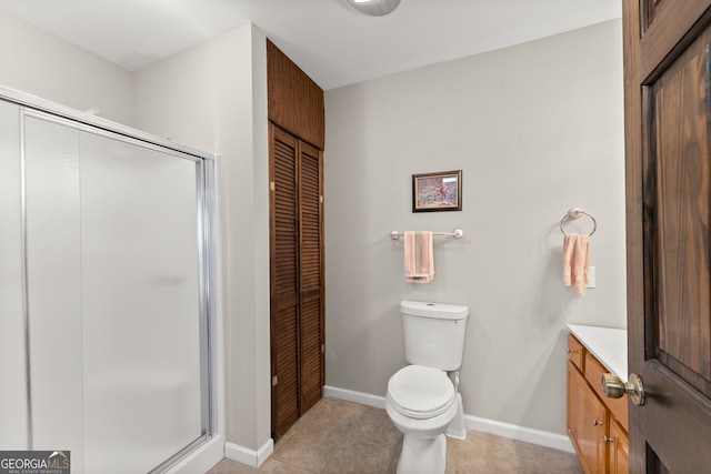 bathroom featuring a closet, toilet, vanity, a shower stall, and tile patterned floors