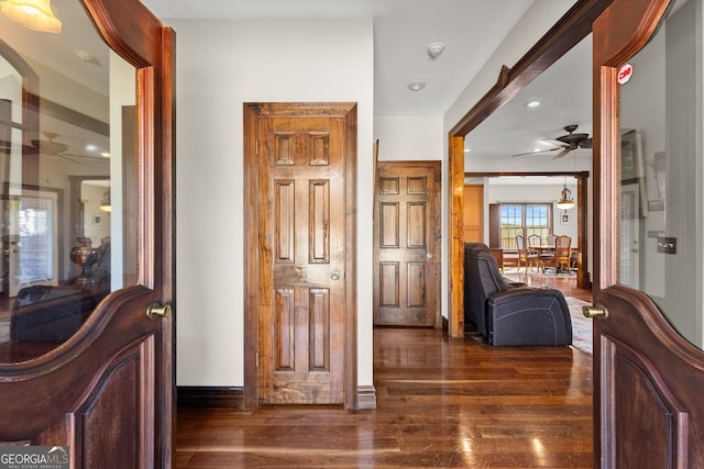 hall with dark wood-style floors and baseboards