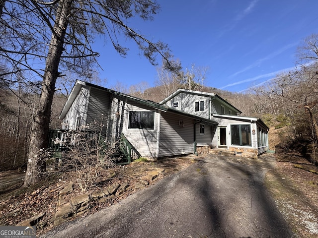 view of front of home featuring aphalt driveway and a sunroom