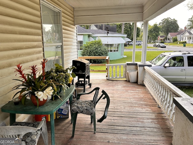 deck with a residential view, covered porch, and a grill