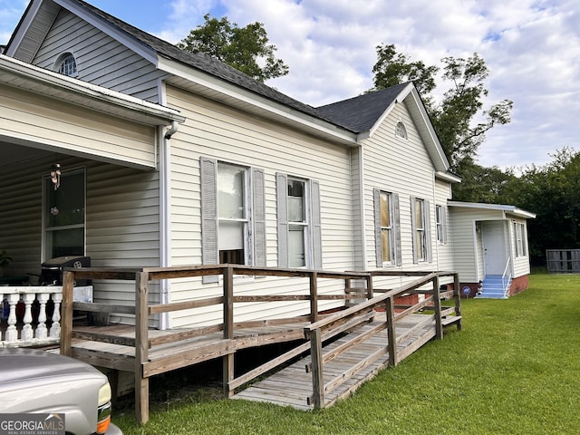 view of property exterior featuring entry steps, a wooden deck, and a yard