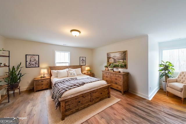 bedroom featuring light wood-type flooring, visible vents, and baseboards