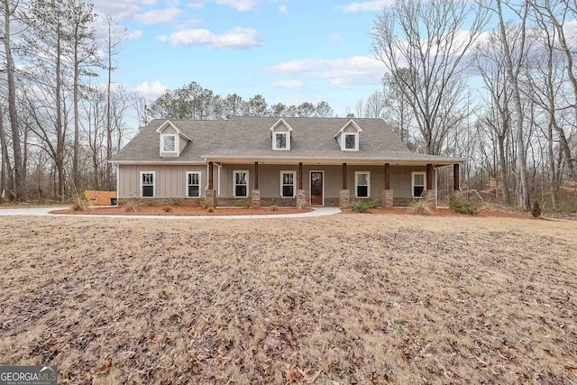 view of front facade with board and batten siding, stone siding, and a porch