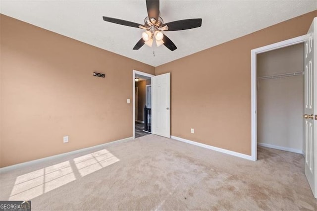 unfurnished bedroom with light carpet, ceiling fan, baseboards, and a closet