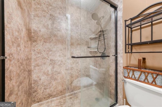 bathroom with a shower stall and toilet