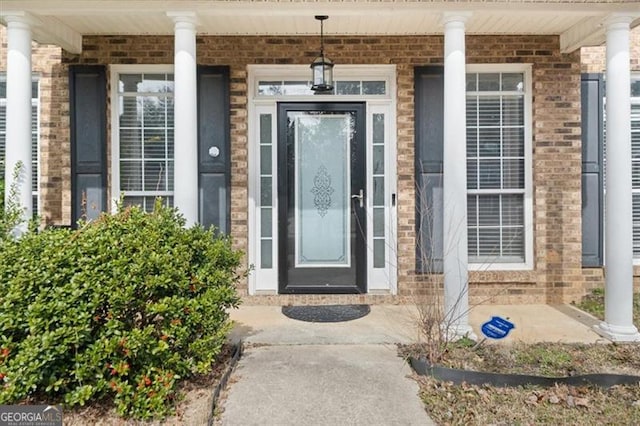 view of exterior entry featuring brick siding