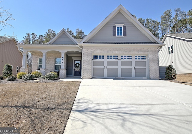 view of front of house featuring a garage, concrete driveway, and brick siding