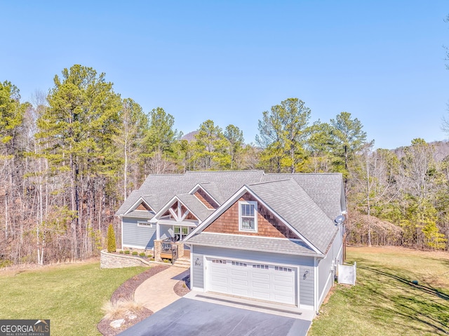 craftsman inspired home featuring a garage, aphalt driveway, a front lawn, and a view of trees