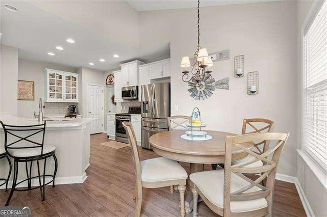 dining space with dark wood-style floors, baseboards, a chandelier, and recessed lighting