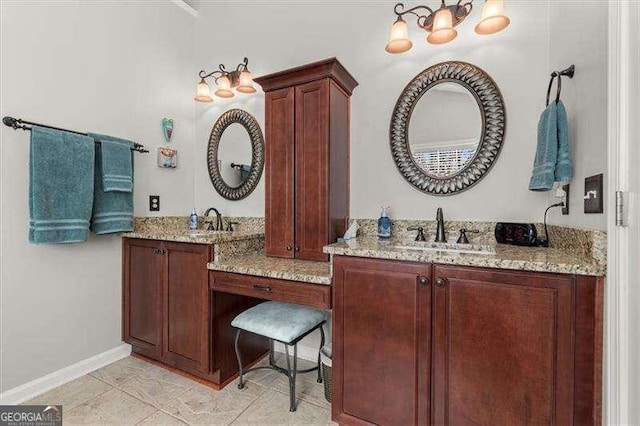 bathroom featuring two vanities, a sink, and baseboards