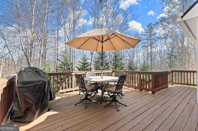 wooden deck featuring a grill and outdoor dining space