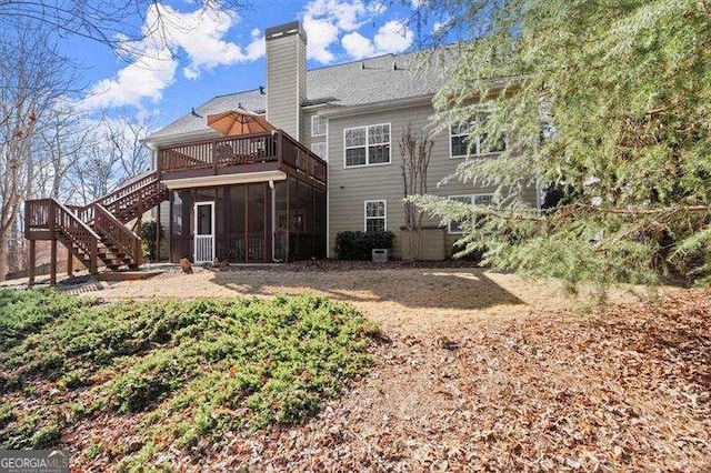 back of house with stairs, a chimney, and a sunroom