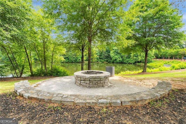 view of patio / terrace featuring an outdoor fire pit and a water view