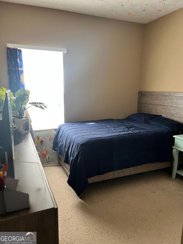 bedroom featuring light colored carpet and a textured ceiling