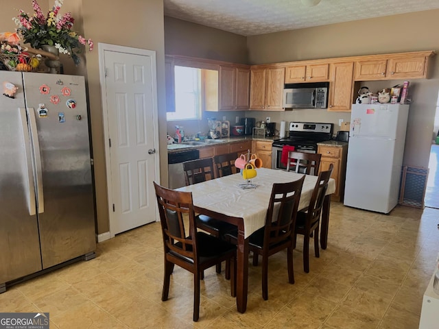 kitchen with appliances with stainless steel finishes and a textured ceiling