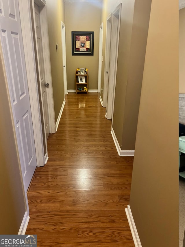 corridor with baseboards and dark wood-style floors