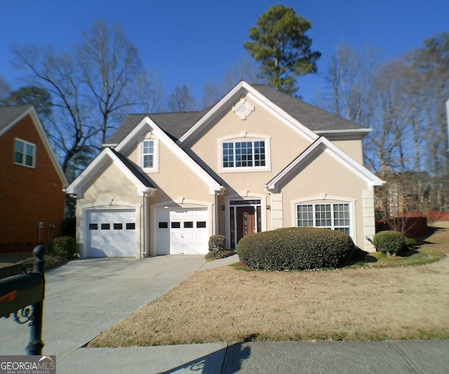 traditional-style house featuring concrete driveway and stucco siding