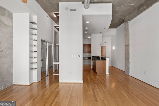 943 Peachtree St NE Unit 2009, Atlanta, GA 30309 - unfurnished living room with built in features, visible vents, a sink, and light wood-style flooring