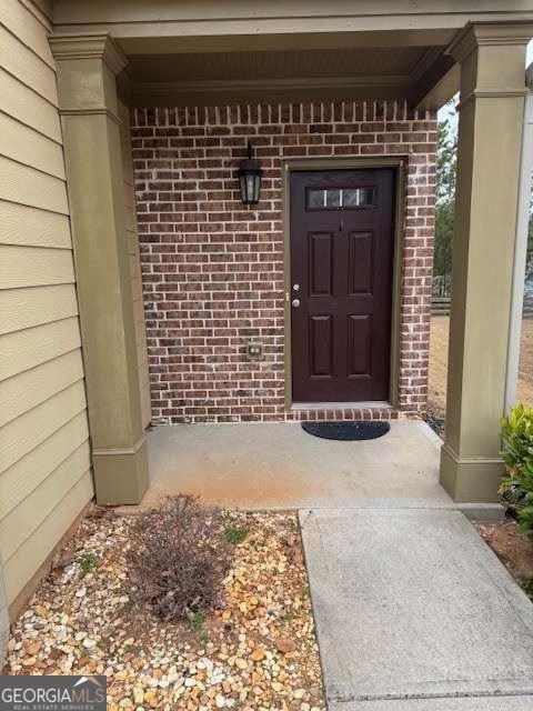 view of exterior entry featuring brick siding