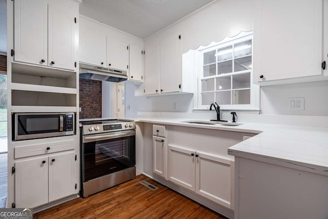 kitchen with stainless steel appliances, light countertops, under cabinet range hood, white cabinetry, and a sink