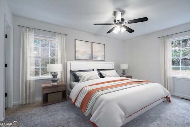 carpeted bedroom with ceiling fan and baseboards