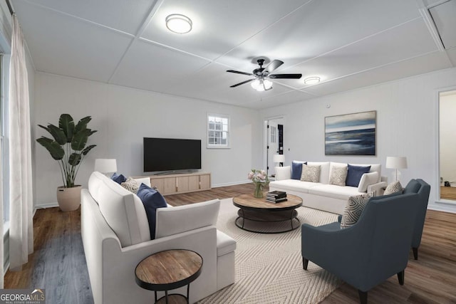 living area with wood finished floors, a ceiling fan, and attic access