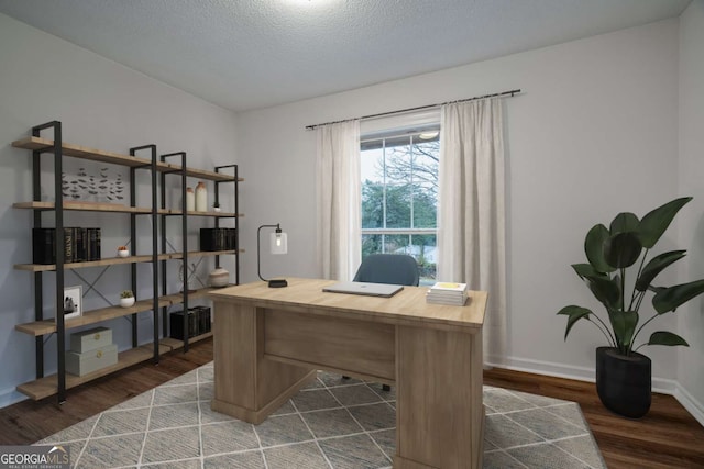 office area with dark wood-style flooring, a textured ceiling, and baseboards