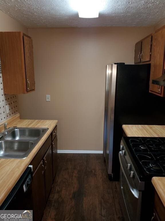 kitchen with light countertops, dishwasher, stainless steel gas range oven, and a sink