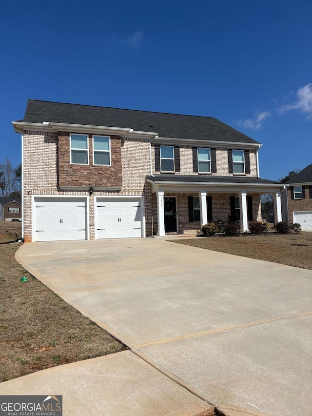 view of front facade featuring driveway, an attached garage, and brick siding