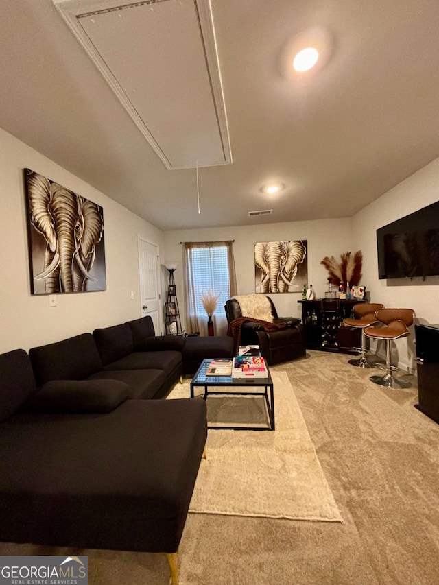 carpeted living area with visible vents and attic access