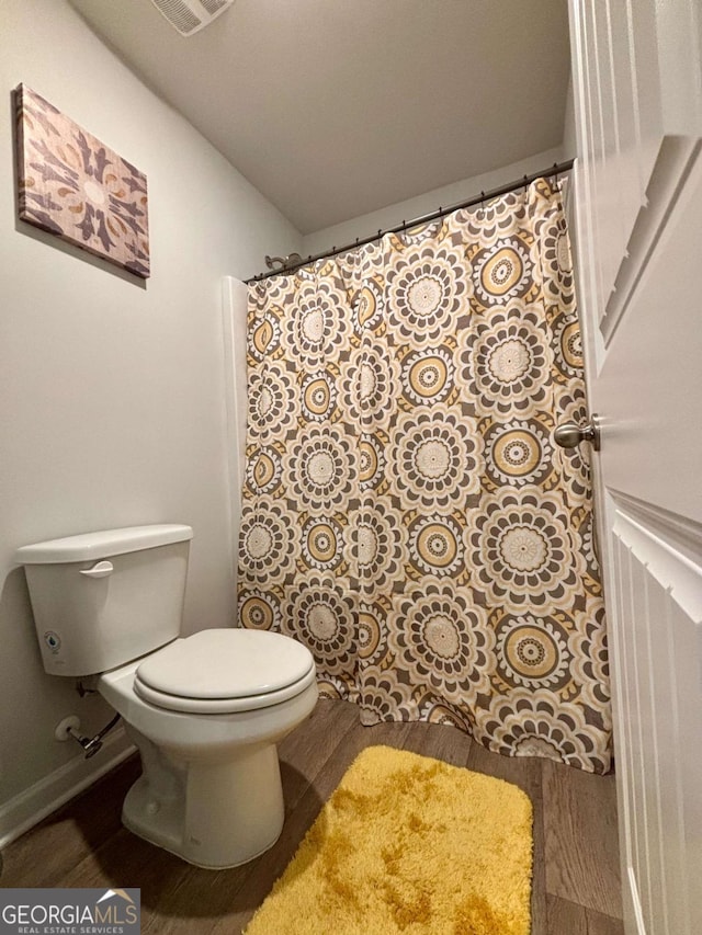 bathroom featuring wood finished floors, toilet, and baseboards