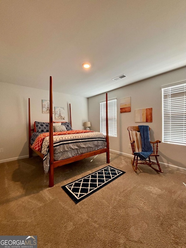 bedroom with carpet floors, visible vents, baseboards, and multiple windows