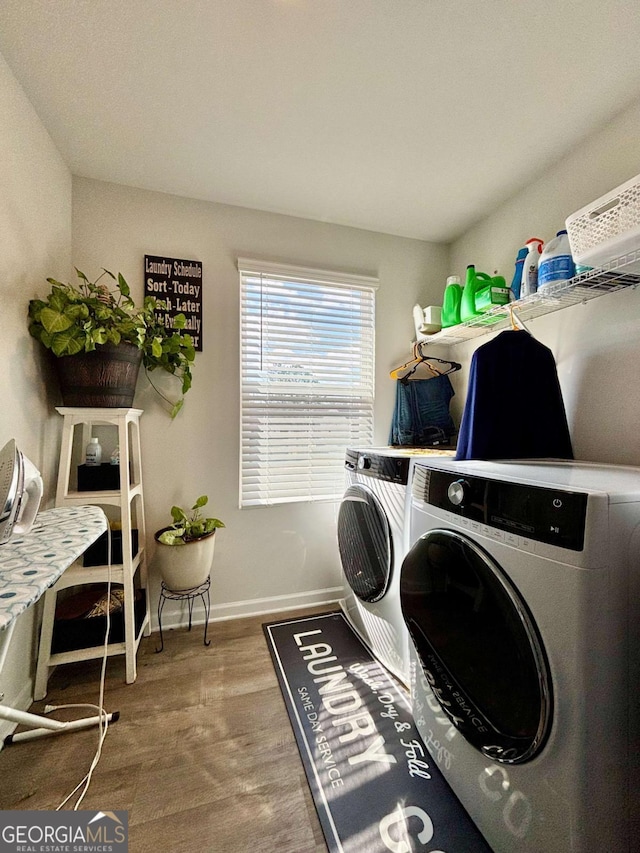 laundry room featuring laundry area, baseboards, wood finished floors, and independent washer and dryer