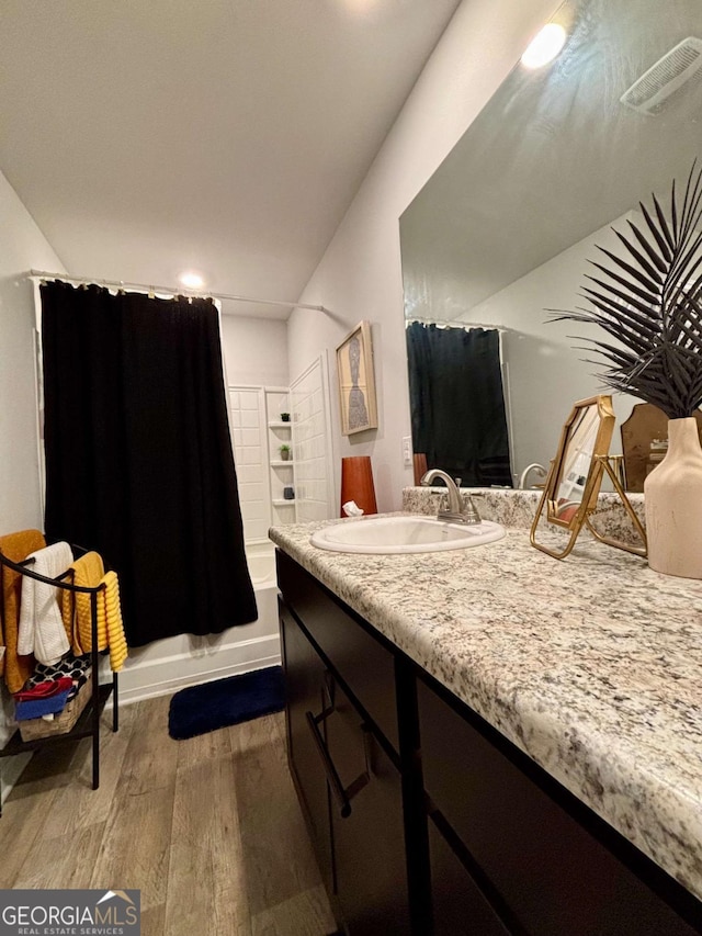 bathroom featuring shower / bath combo, visible vents, vanity, and wood finished floors