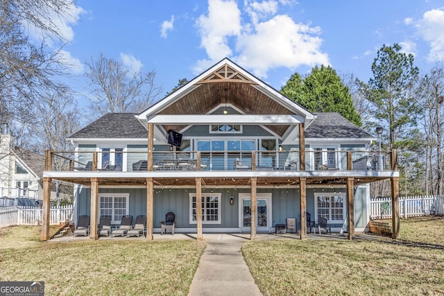 back of house with a yard, roof with shingles, a patio, and fence