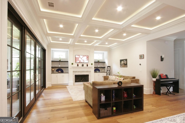 living room featuring a fireplace, visible vents, light wood-style flooring, ornamental molding, and coffered ceiling