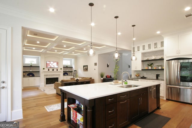 kitchen featuring a fireplace, open shelves, appliances with stainless steel finishes, white cabinetry, and a sink