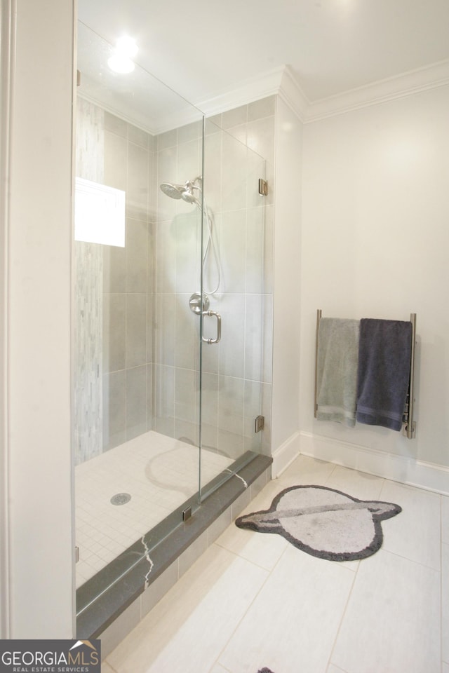 full bathroom featuring a stall shower, tile patterned flooring, ornamental molding, and baseboards