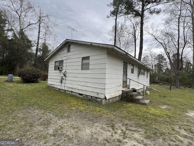 view of side of property featuring crawl space, cooling unit, and a lawn