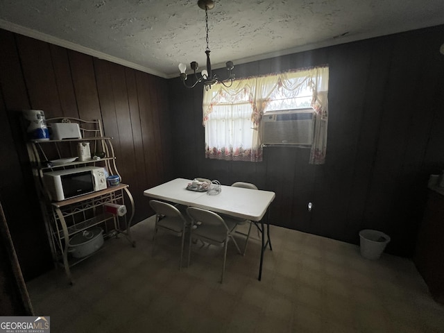 dining room featuring crown molding, a notable chandelier, wooden walls, a textured ceiling, and cooling unit