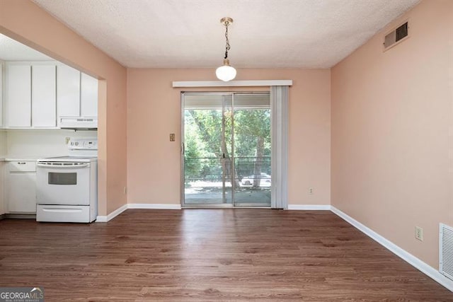 unfurnished dining area featuring visible vents, baseboards, a textured ceiling, and dark wood-style floors