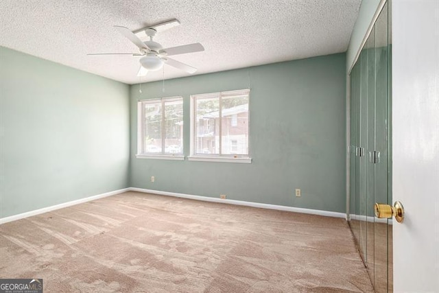 spare room featuring carpet flooring, ceiling fan, a textured ceiling, and baseboards