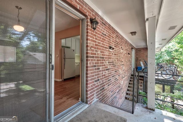 view of exterior entry with visible vents and brick siding