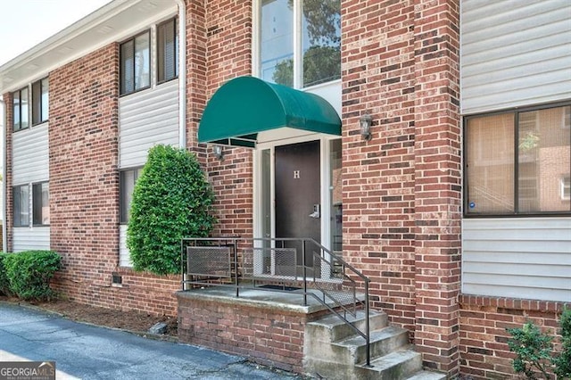 entrance to property featuring brick siding