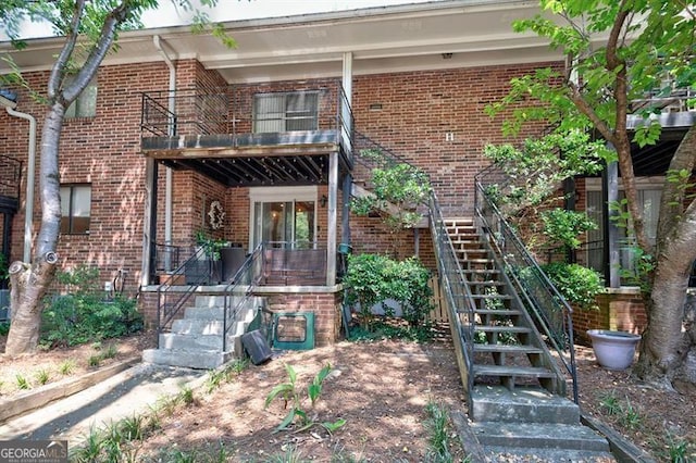 view of front of home with stairway and brick siding