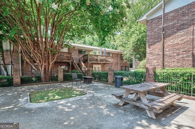 surrounding community with stairway and a patio