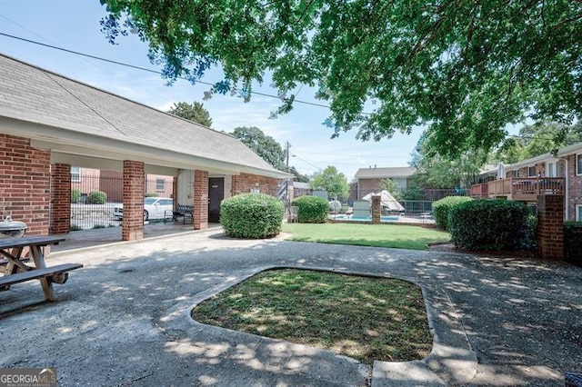 view of property's community featuring a lawn and fence