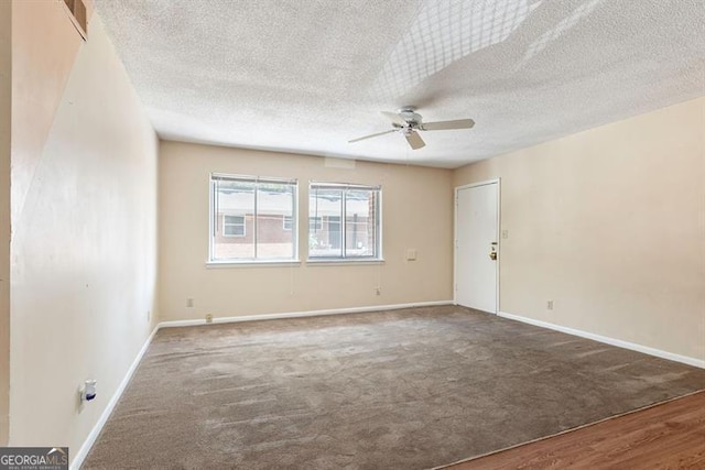 carpeted spare room featuring baseboards, a textured ceiling, and ceiling fan