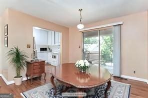 dining space with baseboards and wood finished floors