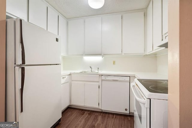 kitchen featuring white appliances, a sink, light countertops, dark wood-type flooring, and a textured ceiling